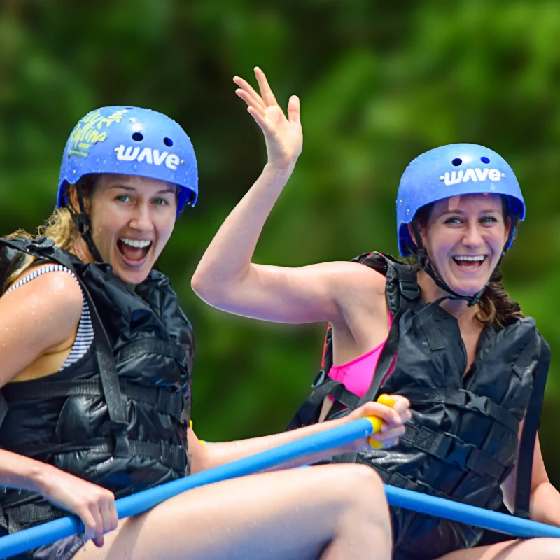 Two happy women enjoying a whitewater rafting tour in Arenal, Costa Rica.
