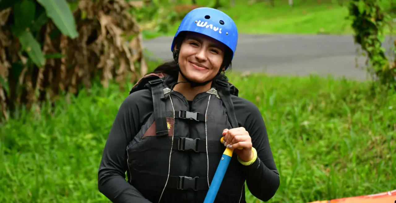 Female rafting smiling in full gear before the tour