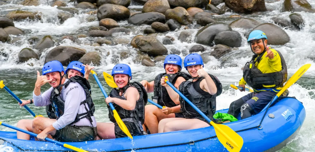 Small group rafting past rocky riverbanks in La Fortuna, Costa Rica