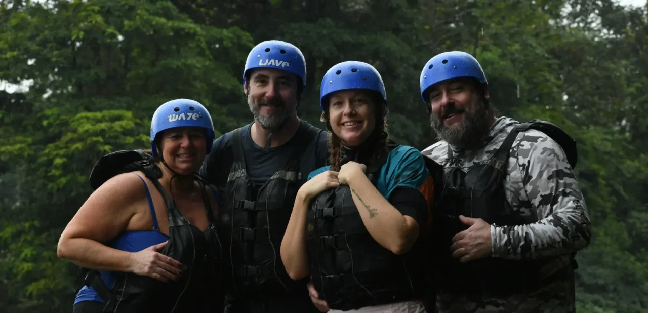 group of travelers smiling after a rafting tour with wave expeditions in costa rica